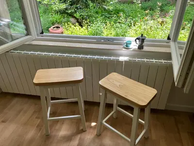 two wooden stools sitting in front of a window at Opera Flat in Sofia
