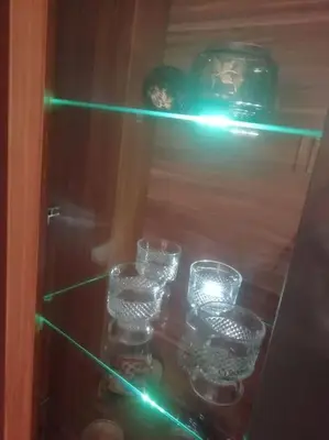 a group of glasses on a shelf with green lights at Sofia Palms: Modern apartment with a large terrace in Sofia