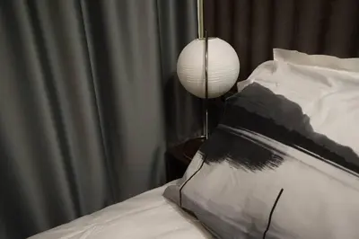 a lamp sitting next to a bed with a pillow at Sofia Zen - on Metro, ultra fast Wi-Fi in Sofia