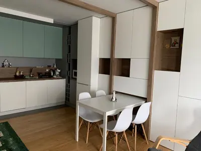 a kitchen with white cabinets and a table and chairs at Niko's deluxe apartment in Sofia