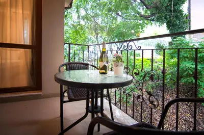 a table with a bottle of wine on a balcony at Odrys Apartments in Plovdiv