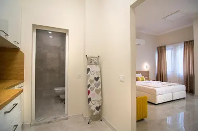 a hotel room with a bed and a bathroom at Odrys Apartments in Plovdiv