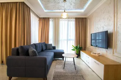 a living room with a blue couch and a tv at Odrys Apartments in Plovdiv
