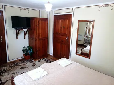 a room with a table and a mirror and a television at Guest Rooms Dona in Koprivshtitsa