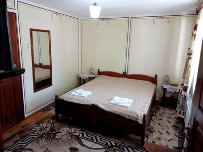 a small bedroom with a bed and a mirror at Guest Rooms Dona in Koprivshtitsa