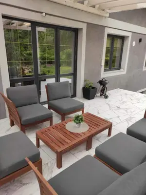 a patio with chairs and a wooden table and chairs at Wellnesshouse Müller in Ilindentsi
