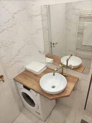 a bathroom with two sinks and a washing machine at Wellnesshouse Müller in Ilindentsi