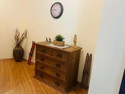 a room with a dresser with a clock on the wall at Apartment in Bansko, very close to the Gondola in Bansko