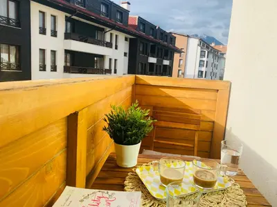 a table with glasses of wine on a balcony at Apartment in Bansko, very close to the Gondola in Bansko