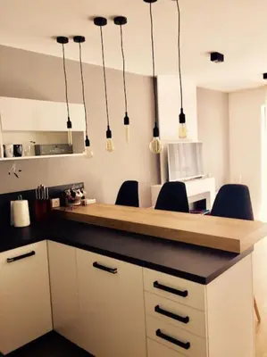 a kitchen with a counter with chairs and lights at 2 BED APARTMENT IN BANSKO RESORT in Bansko
