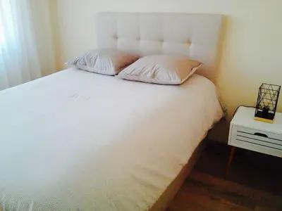 a white bed with two pillows on top of it at 2 BED APARTMENT IN BANSKO RESORT in Bansko