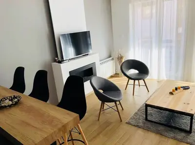 a living room with chairs and a table and a television at 2 BED APARTMENT IN BANSKO RESORT in Bansko