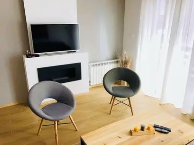 two chairs sitting in a living room with a tv at 2 BED APARTMENT IN BANSKO RESORT in Bansko