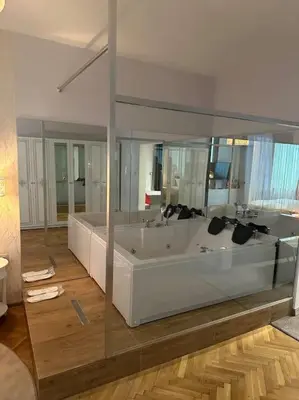 a large bathroom with a tub and a large mirror at Luxury apartment with Jacuzzi in Sofia