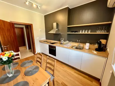 a kitchen with a wooden table and a kitchen with a sink at LOCATION ! LOCATION ! LOCATION ! City Garden View Oak apartment in Sofia