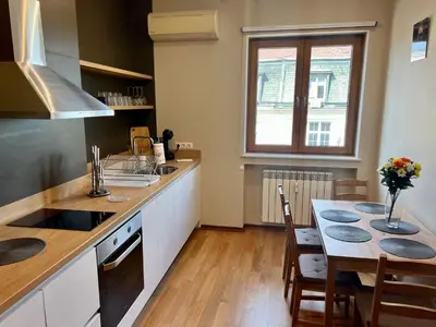 a kitchen with a table and a dining room at LOCATION ! LOCATION ! LOCATION ! City Garden View Oak apartment in Sofia