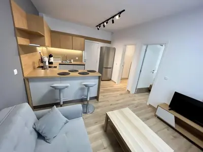a living room with a white couch and a kitchen at LOCATION ! Sofia Opera Apartment next to ALEXANDER NEVSKY CATHEDRAL in Sofia