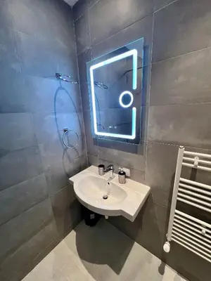 a bathroom with a sink and a neon sign on the wall at LOCATION ! Sofia Opera View Apartment next to ALEXANDER NEVSKY CATHEDRAL in Sofia