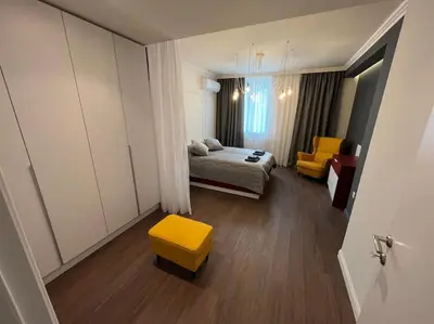 a bedroom with a bed and a yellow stool at LOCATION ! LOCATION ! LOCATION ! City Garden View Apartment in Sofia