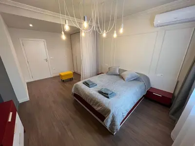 a bedroom with a large bed and a chandelier at LOCATION ! LOCATION ! LOCATION ! City Garden View Apartment in Sofia