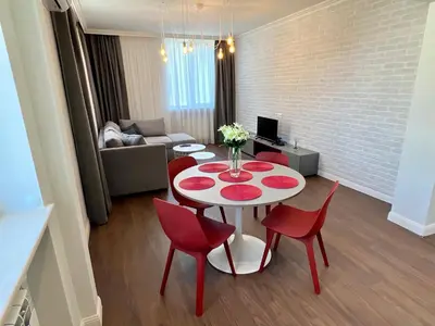 a living room with a table and red chairs at LOCATION ! LOCATION ! LOCATION ! City Garden View Apartment in Sofia
