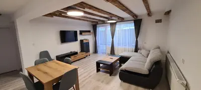 a living room with a couch and a table at Апартаменти Сънрайс Чепеларе in Chepelare