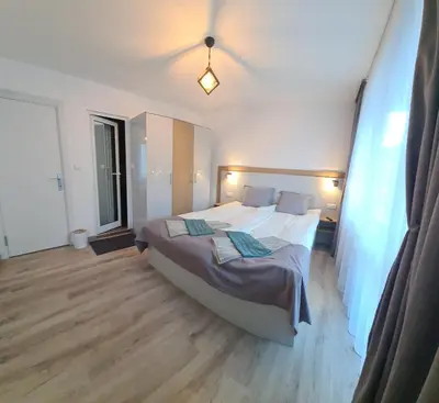 a bedroom with a large bed and a large window at Апартаменти Сънрайс Чепеларе in Chepelare