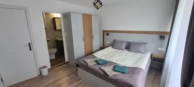 a small bedroom with a bed and a bathroom at Апартаменти Сънрайс Чепеларе in Chepelare