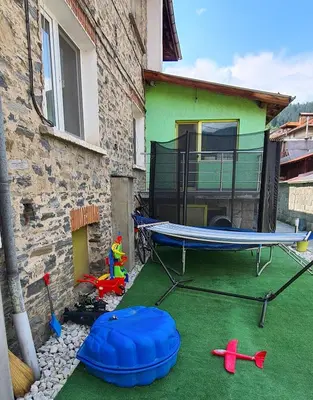 a backyard with a trampoline and a house at Апартаменти Сънрайс Чепеларе in Chepelare