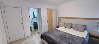 a bedroom with a bed and a bathroom at Апартаменти Сънрайс Чепеларе in Chepelare