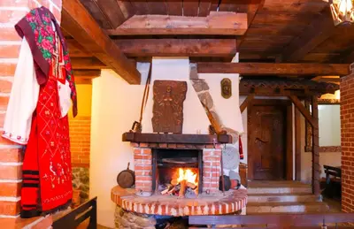 a brick fireplace in a room with a fire at Семеен хотел Света Марина in Dobrinishte
