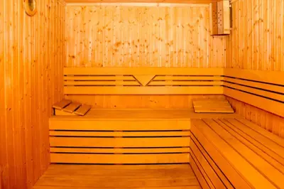 an empty sauna with wooden walls and wooden floors at Семеен хотел Света Марина in Dobrinishte