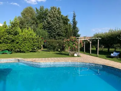 a large blue swimming pool in a yard at Galeria In The Garden in Plovdiv