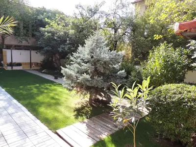 a garden with a wooden bench in the grass at Apartments in Relax Complex Fantasy in Hisarya