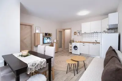 a kitchen and living room with a table and a dining room at Cozy home next to Aliosha - Boho Stay in the heart of Plovdiv in Plovdiv