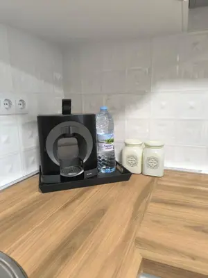a microwave with a bottle of water and two candles at Cozy home next to Aliosha - Boho Stay in the heart of Plovdiv in Plovdiv