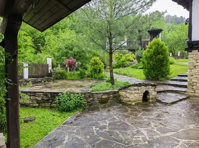 a stone walkway in a yard with a stone wall at Къща за гости КИМ in Apriltsi