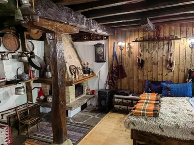 a room with a bed and a fireplace in it at Къща за гости КИМ in Apriltsi