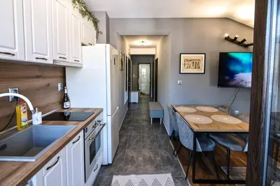 a kitchen with a table and a dining room at Мансарда с фантастични гледки и две спални in Chepelare
