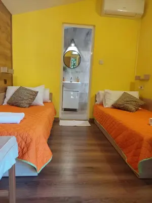 two beds in a room with yellow walls at Green View 1 in Skrino
