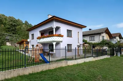 a white house with a fence and a yard at Къща за гости Остриля in Cherni Vit
