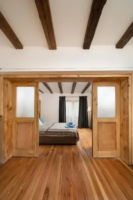 a bedroom with a bed and two sliding doors at Къща за гости Остриля in Cherni Vit