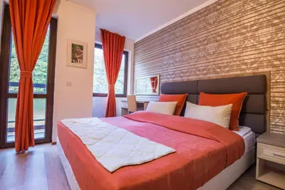 a bedroom with a large bed and a brick wall at STENATA Sport Apartments in Pamporovo