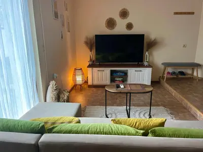 a living room with a couch and a flat screen tv at Вила Форте Villa Forte in Pamporovo