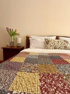 a bed with a patchwork quilt on top of it at Cedar Heights 2 in Pamporovo