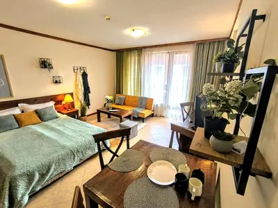 a bedroom with a bed and a living room at Luxury SPA Apartments TOP resort Bansko - incl wellness in Bansko