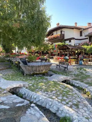 a park with benches and a fountain and a building at Belvedere Holiday Club H41 in Bansko