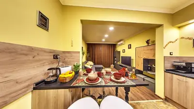 a kitchen with yellow walls and a table with food on it at Comfort & Cozy Apartment in Sofia Center in Sofia