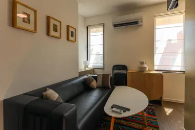a living room with a black leather couch and a table at Old Town View in Plovdiv