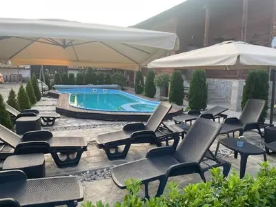 a group of chairs and umbrellas next to a pool at Villa Le Cinema in Shiroki Dol